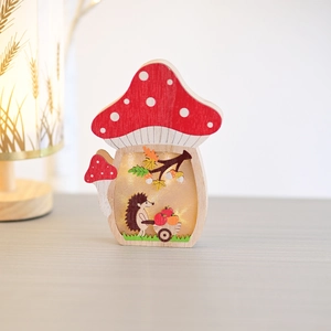 Detail of wooden mushroom night light featuring a carved hedgehog and warm LED glow