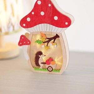 Detail of wooden mushroom LED light with hedgehog scene and warm harvest festival glow