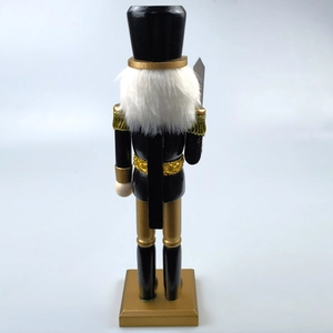 Detail of Nutcracker soldier back view with black hat, gold tassels and white fiber hair