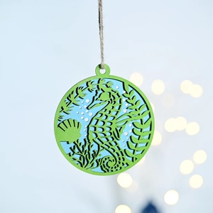 Detail of laser-cut wooden seahorse pendant with blue and green layers and hemp rope