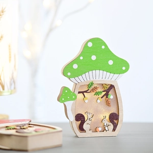Close-up of wooden mushroom LED light with hollow carved squirrel and forest patterns