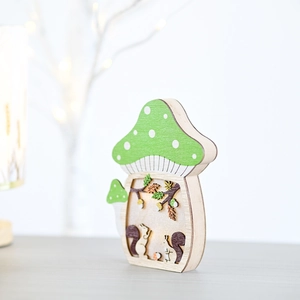 Detailed laser-cut layers of squirrel and forest inside a wooden mushroom lamp