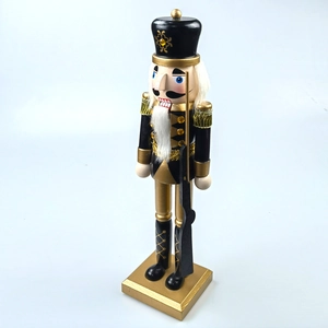 Close-up of black and gold nutcracker soldier figurine with detailed golden epaulets