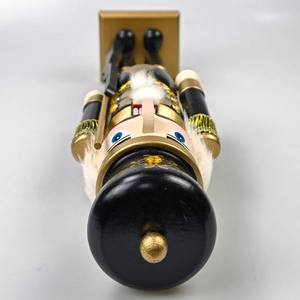 Close-up of black and gold Nutcracker soldier with glitter details and white fur beard