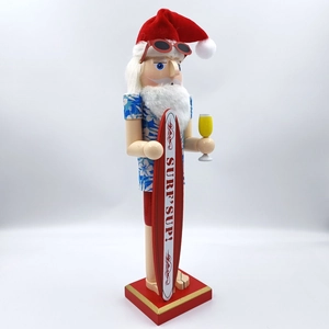 Detailed wood craftsmanship of a Hawaiian Santa nutcracker with surfboard and drink