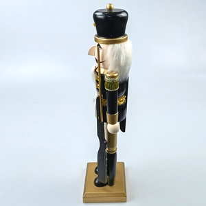Detailed side view of black and gold Nutcracker soldier ornament with a stable base