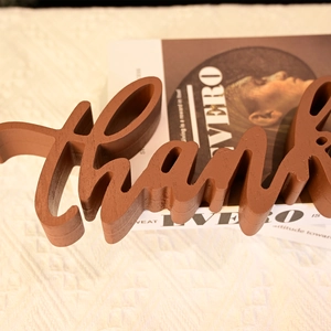 Wooden Thanksgiving 'thank' sign ornament placed on a white textile for home desk decor