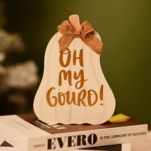 Detail of wooden pumpkin decor with burlap bow and Oh my Gourd text on books
