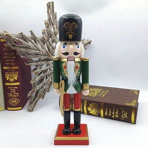Detail of hand-painted wooden nutcracker soldier with gold sword and red base decor