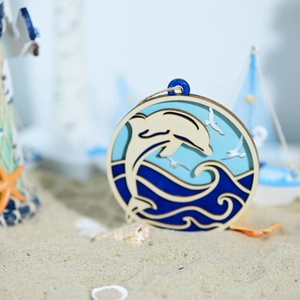 Macro detail of multi-layered wooden ocean hanging ornament with dolphin and sea waves