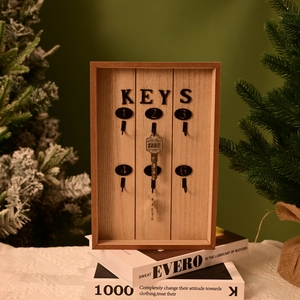 Detail of wooden key organizer with six metal hooks and KEYS lettering on green background