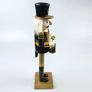 Detail view of black and gold nutcracker soldier ornament with drum and golden base