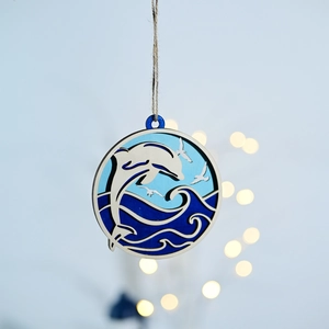 Detail of multi-layered wooden ocean ornament with carved dolphin and waves scene