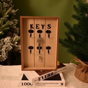 Detail of wooden key holder box with six metal hooks and decorative KEYS lettering