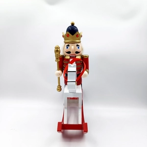Detail of traditional nutcracker king on a red and white rocking horse base ornament