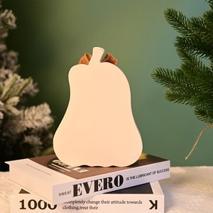 White wooden pumpkin table decor with burlap bow on decorative books for autumn festivals