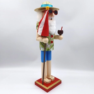 Detail of tropical nutcracker in Hawaiian shirt holding a coconut drink and flag