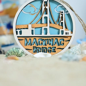 Detail of wooden Mackinac Bridge wall hanging with jute rope in a beach sand setting