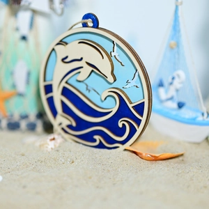 Detail of round laser-cut wooden marine decor featuring dolphins and ocean waves