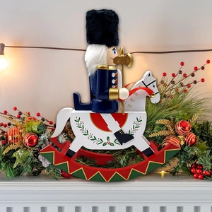 Close-up of wooden nutcracker soldier on rocking horse with festive Christmas decor