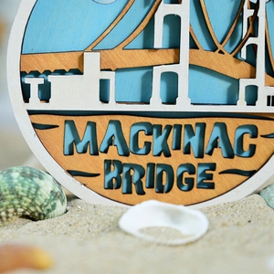 Detailed close-up of multi-layer wooden Mackinac Bridge wall decor with natural sand
