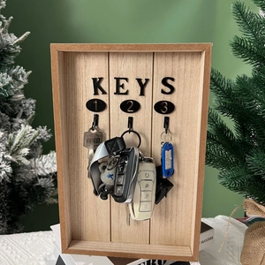 Close-up of wooden wall-mounted key holder with three hooks and black KEYS lettering