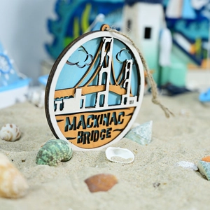 Detail of wooden Mackinac Bridge wall hanging with shells and sand in nautical scene
