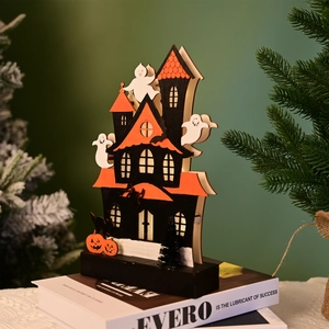 Detail of a lighted Halloween wooden haunted house with ghostly figures and warm LED glow