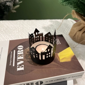 Nordic black metal house silhouette candle holder with a burning white tea light candle