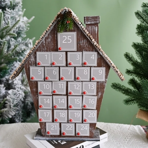 Close-up of wooden house advent calendar with numbered grey doors and festive greenery