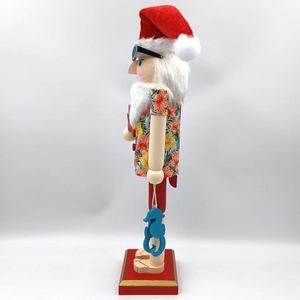 Detail of wooden nutcracker in Hawaiian shirt with sunglasses and blue seahorse charm