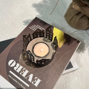 Detailed top view of a black metal house silhouette candle holder with a tea light