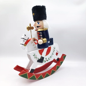 Detail of wooden nutcracker soldier on rocking horse with golden axe for Christmas decor