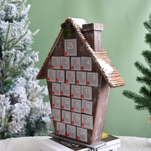Close-up of a wooden house-shaped advent calendar with 25 gray numbered drawers for Christmas