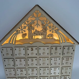 Macro detail of wooden advent calendar featuring nativity scene with warm LED lighting