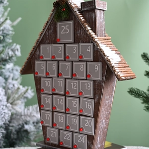 Close-up of wooden advent calendar featuring 25 numbered drawers with snowy accents