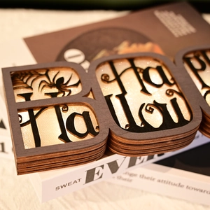Detail of multi-layer wooden BOO sign with Happy Halloween cutout and spider web pattern