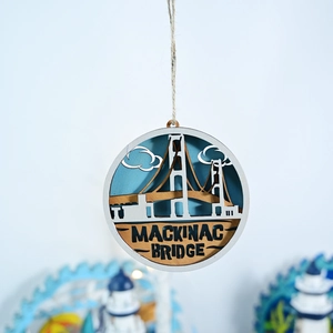 Detail of multi-layered wooden Mackinac Bridge ornament with laser-cut nautical design