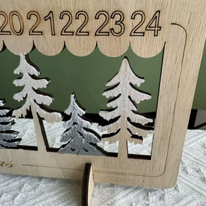 Macro detail of wooden Christmas countdown calendar with laser-cut trees and glitter snow