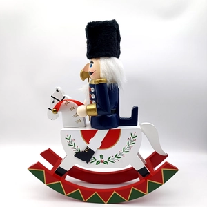 Close-up of a 30.5cm wooden nutcracker soldier riding a white rocking horse figurine