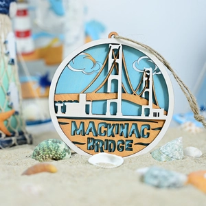 Detail of 3D laser-cut wooden Mackinac Bridge wall decor with shells on sand