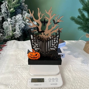 Detail shot of a wooden Halloween ornament showing 98.2g weight on a scale