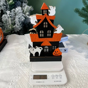 Detail view of Halloween wooden haunted house decor on a scale weighing 81.9g