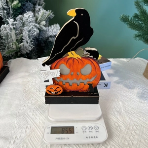 Close-up of wooden Halloween crow and pumpkin ornament showing 85.5g weight detail