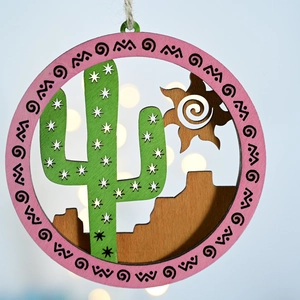 Detail of wooden wall hanging with laser-cut desert scene and tribal patterns