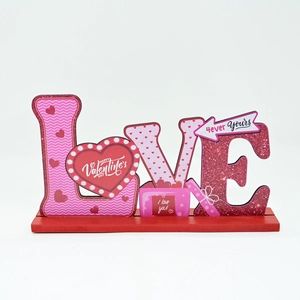 Détail du décor en bois LOVE pour la Saint-Valentin avec motifs cœurs et texte festif