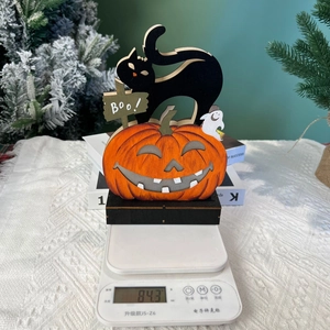 Detailed view of Halloween wood ornament on a scale showing 84.3g net weight