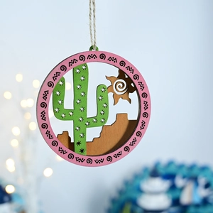 Detail of wooden ocean-themed hanging decor with laser-cut cactus and sun patterns