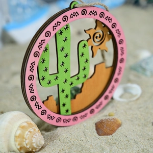Close-up of circular laser-cut wooden cactus ornament with tropical beach decor