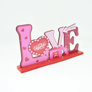 Détail du décor en bois LOVE avec motifs de cœurs roses et texte de la Saint-Valentin